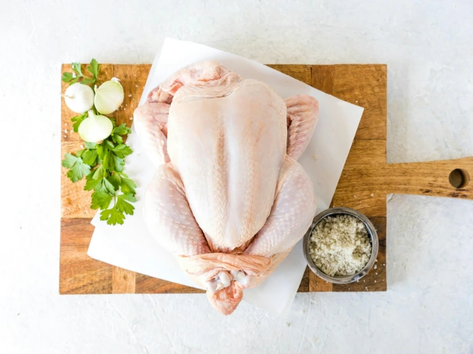 a raw chicken sitting on top of a cutting board
